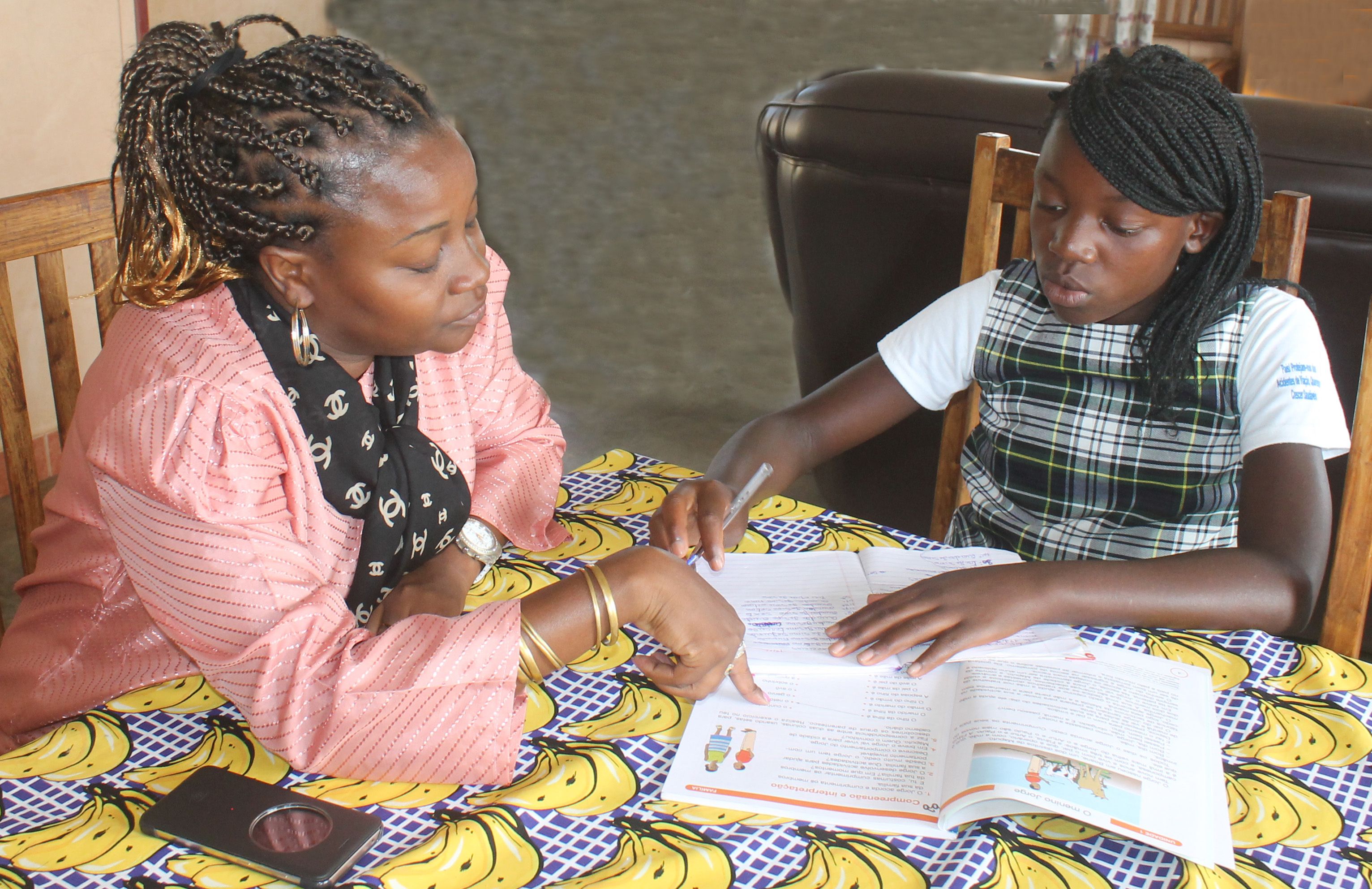 Iyana och hennes barnbymamma Clarence sitter vid bordet och gör läxorna. 