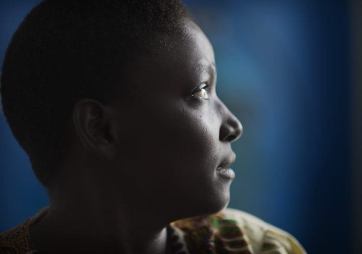 Kvinna i profil framför en blå vägg.