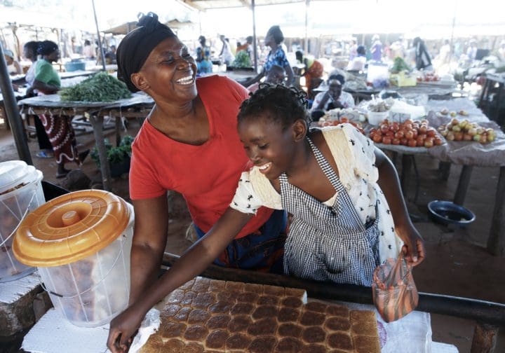 Mamma och dotter säljer bröd på en marknad.