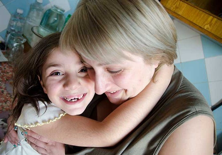 Innerlig kram till mamma från glad flicka.