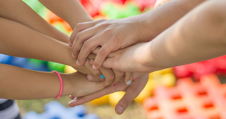 utsträckta händer som lagts på varandra.