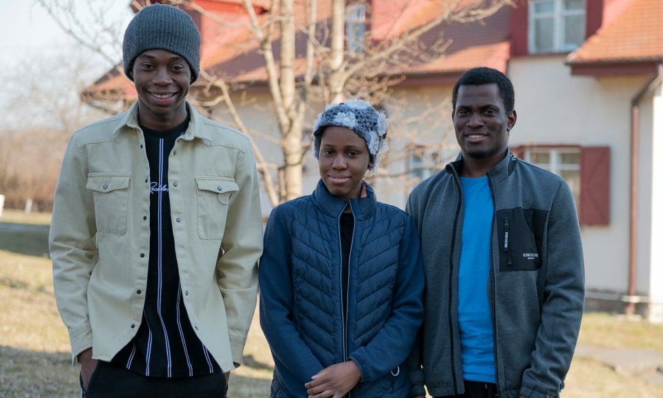 Tre personer som står utanför en SOS Barnbyars lokaler i Rumänien.