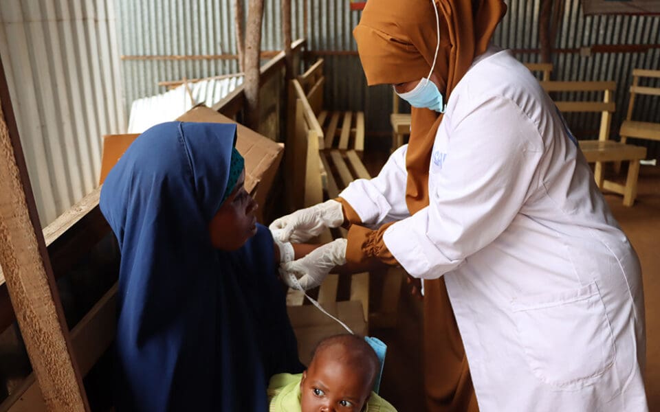 Mamma och barn hjälp av sjuksköterska på SOS Barnbyars klinik.