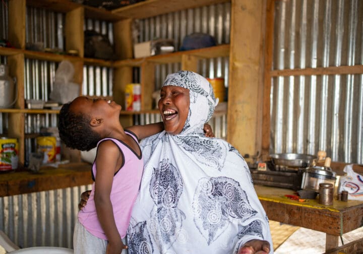 En kvinna som deltar i SOS Barnbyars familjestärkande program skrattar tillsammans med hennes barn.