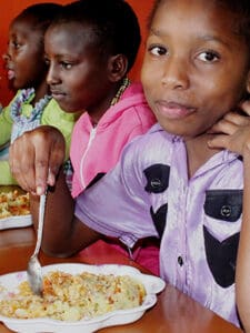 flicka i lila skjorta äter mos