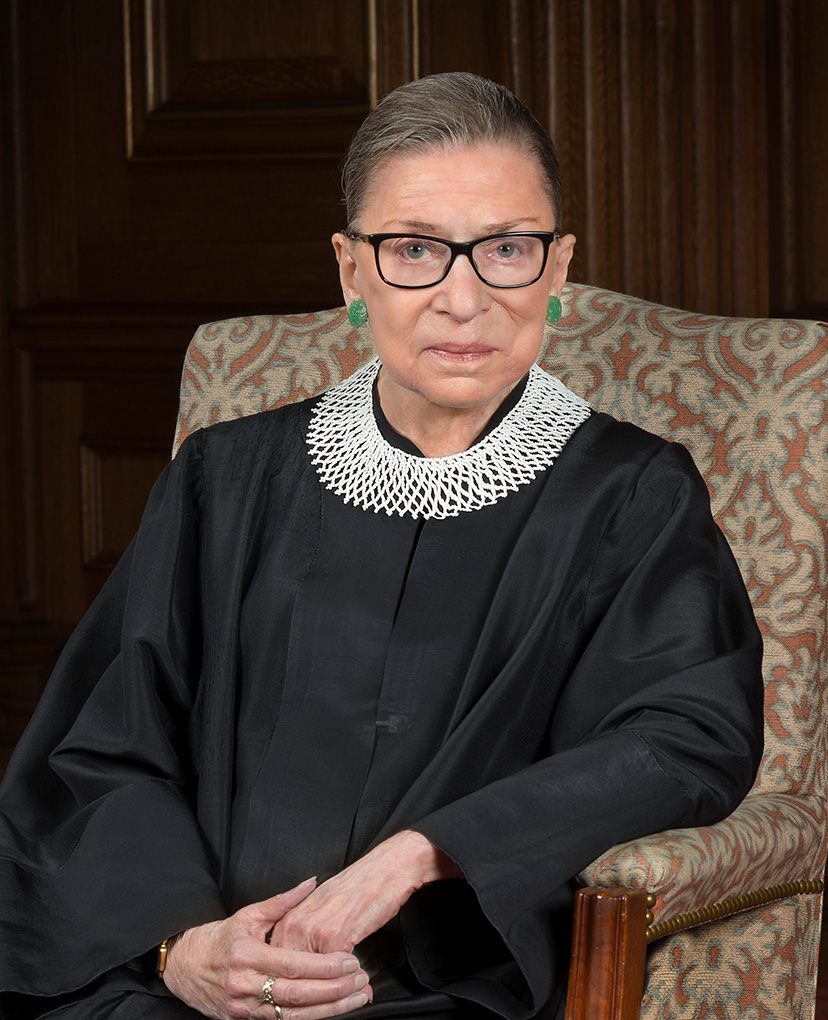 äldre kvinna med glasögon, en svart rock och vit krage.