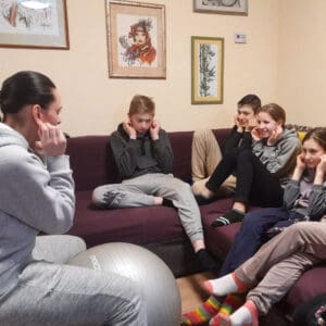 En kvinna sitter framför en grupp med barn