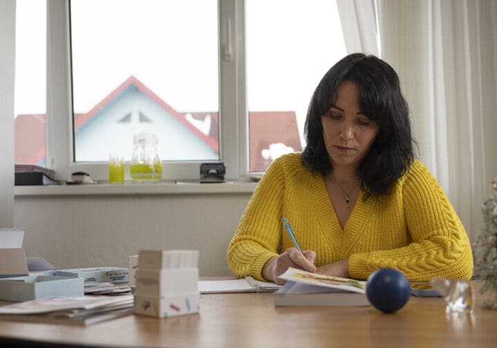 Anna sitter vid ett skrivbord och arbetar.