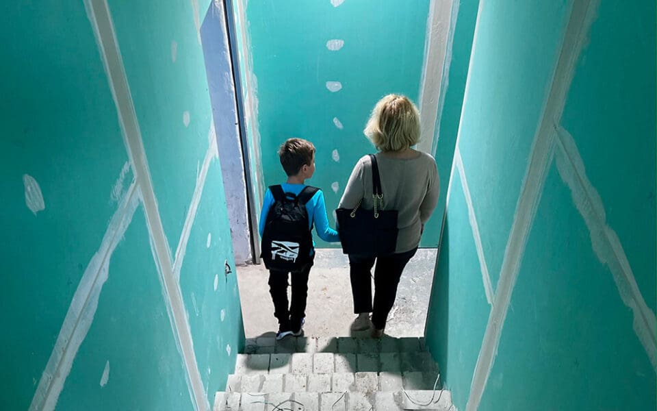 En kvinna och en pojke som går ner för en trappa.