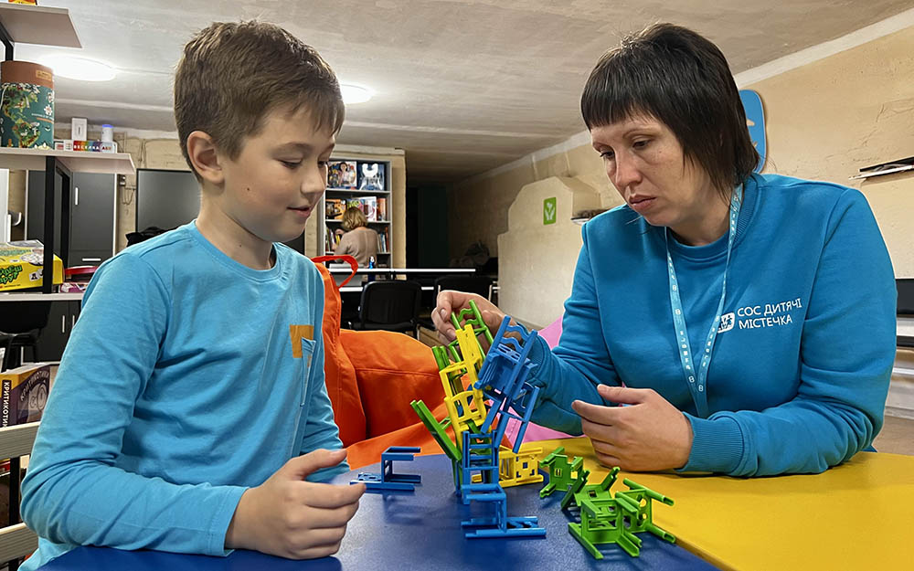 Att barn och en anställd från SOS Barnbyar.