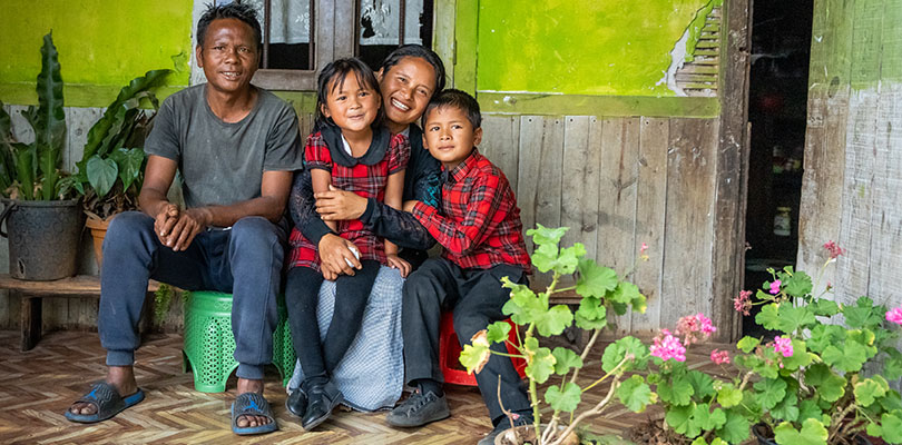 En pappa, mamma och två barn sitter tillsammans utomhus