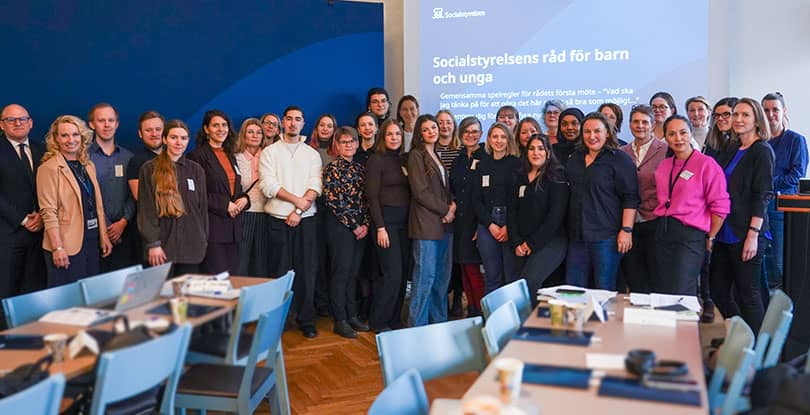 Ett tjugotal människor står på rad i en föreläsningssal
