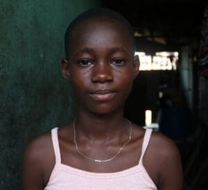 allvarlig flicka i rosa linne tittar rakt fram