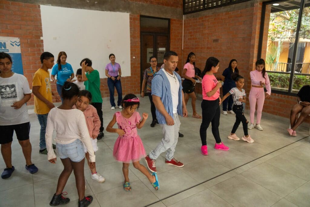 Barn och en vuxen dansar i en gymnastiksal