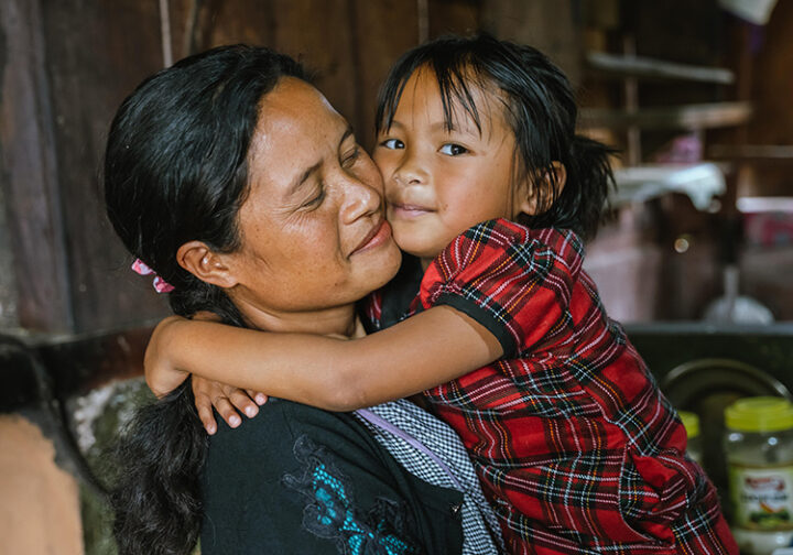 En kvinna och ett barn som kramas.