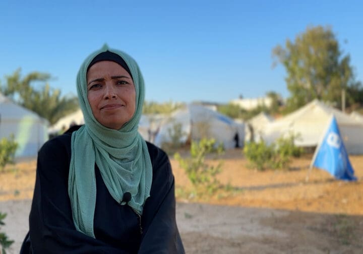 Kvinna framför tältläger.