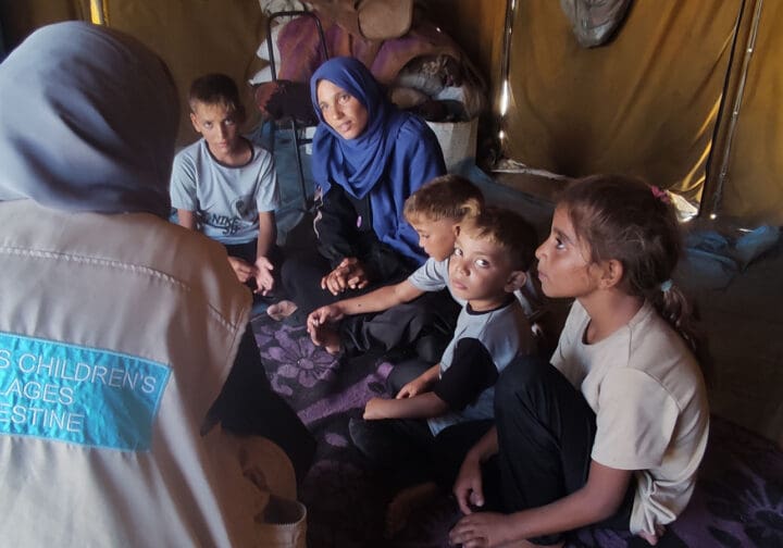 Familj och SOS Barnbyars medarbetare i ett tält i Gaza.